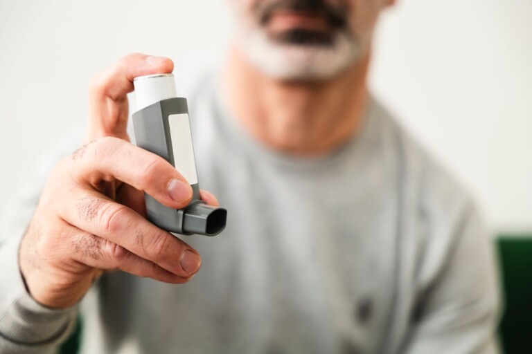 Homme utilisant un inhalateur, prise en charge respiratoire de la BPCO